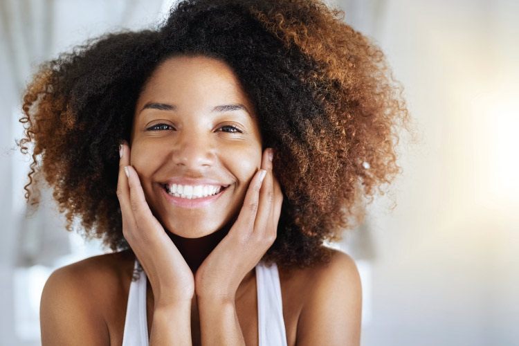 Brunette woman smiles after receiving a teeth cleaning at Trillium Dental in Portland, OR