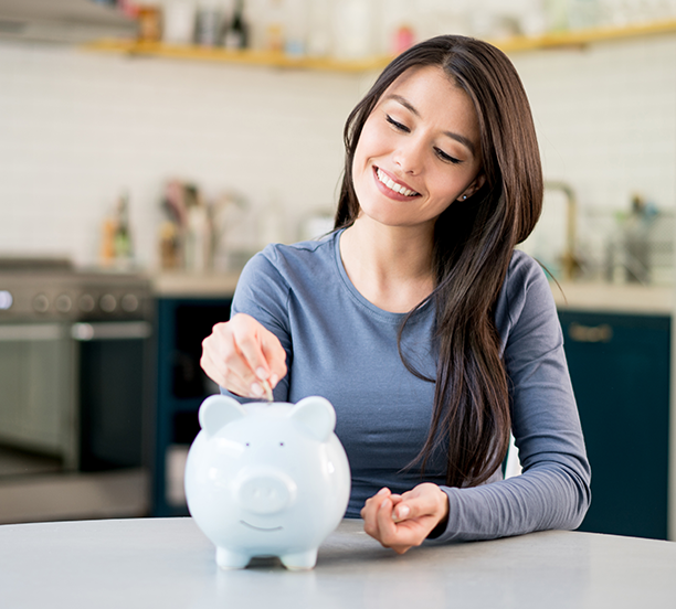 woman adding money to piggy bank