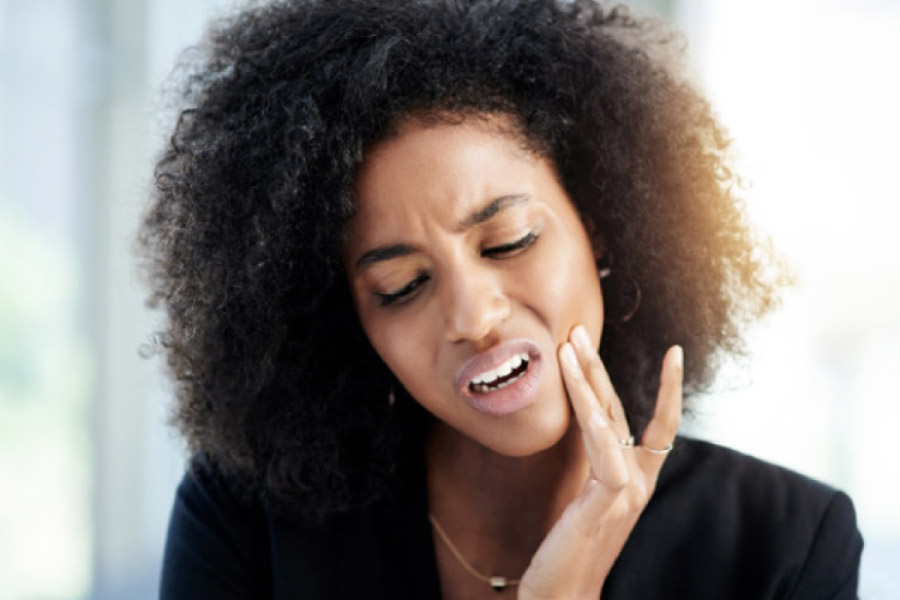 woman holds her jaw in pain with a dental emergency