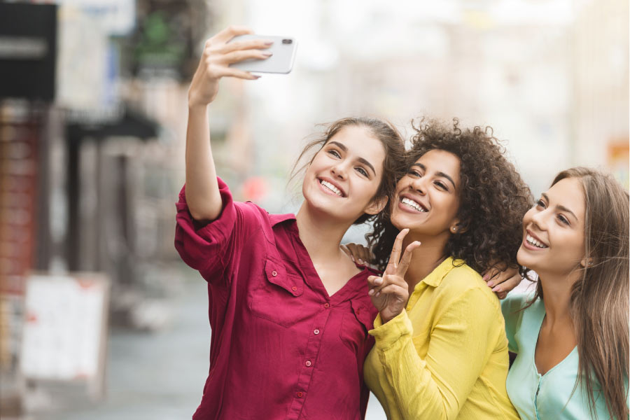 three young women pose for a selfie to show off their white, straight teeth