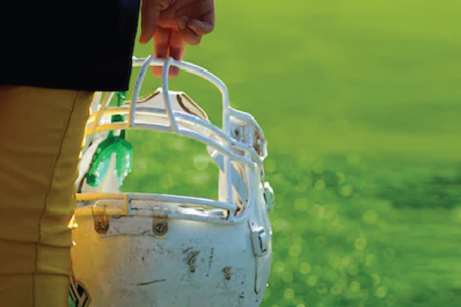 football helmet and mouthguard held by two fingers