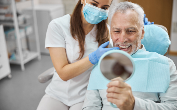 man at dentist looking in mirror