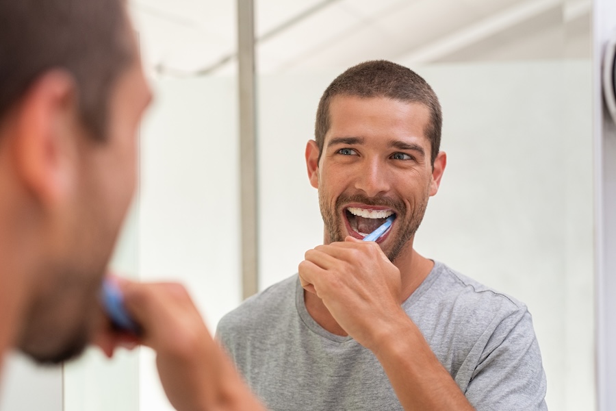 man brushing his teeth, healthy habits for healthy teeth